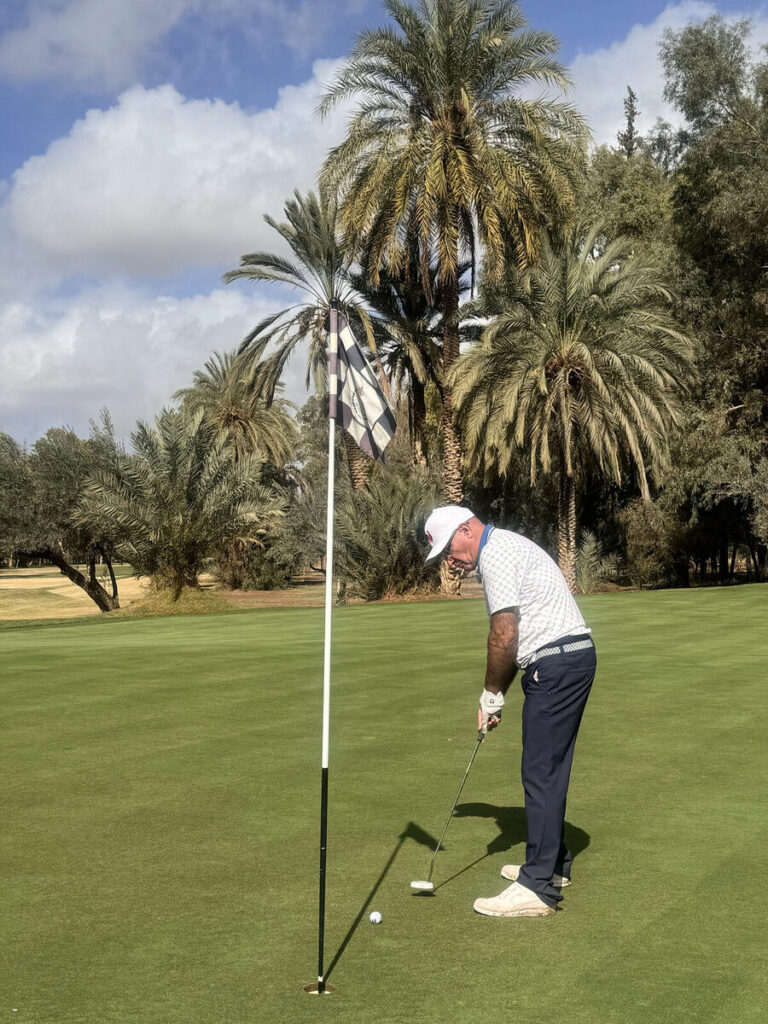 Un golfeur sur un green entouré de palmiers à Marrakech